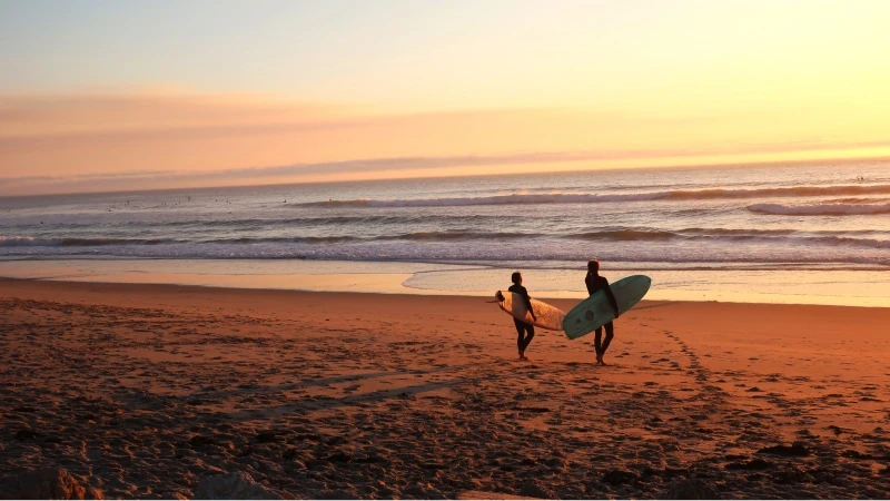 Surfers op een beachbreak op zoek naar golven