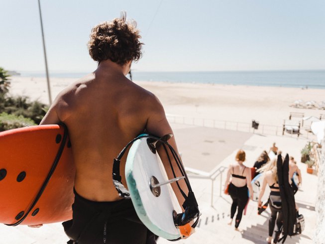 Naar de surfles lopen met deskundige instructeur en enthousiaste studenten