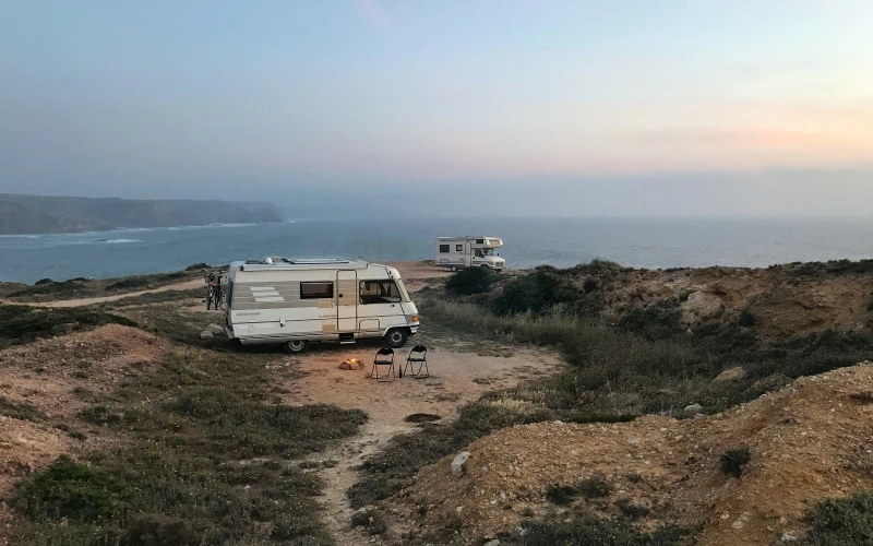 Campers bij Praia de Amado in Portugal met uitzicht op de surf.